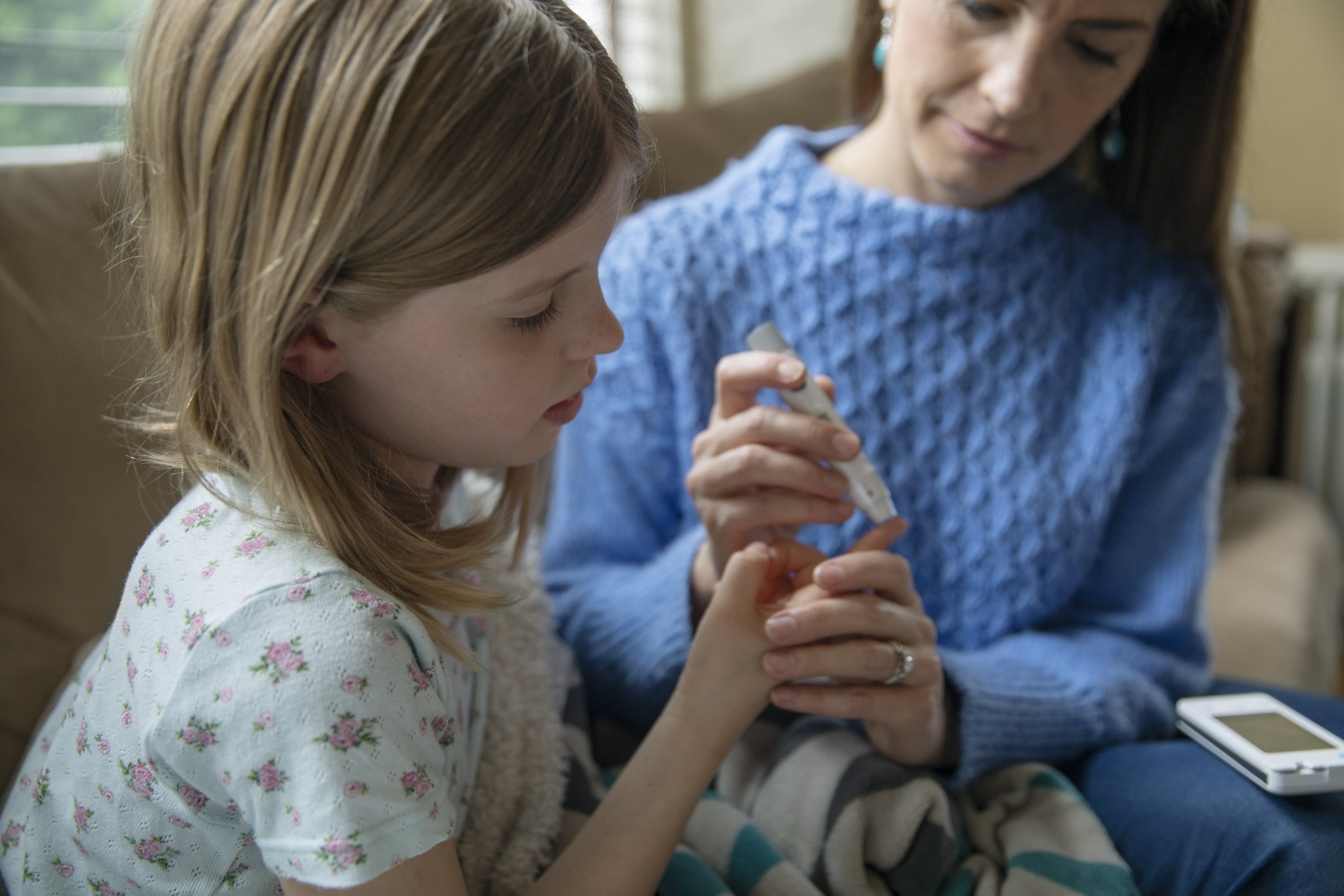 Imagen de madre comprobando el azúcar de su hija