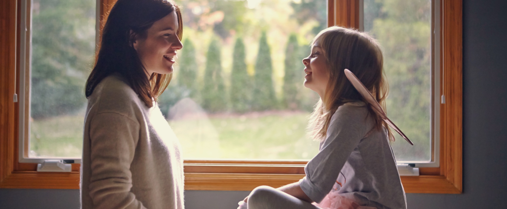 Mujer con su hija en la ventana